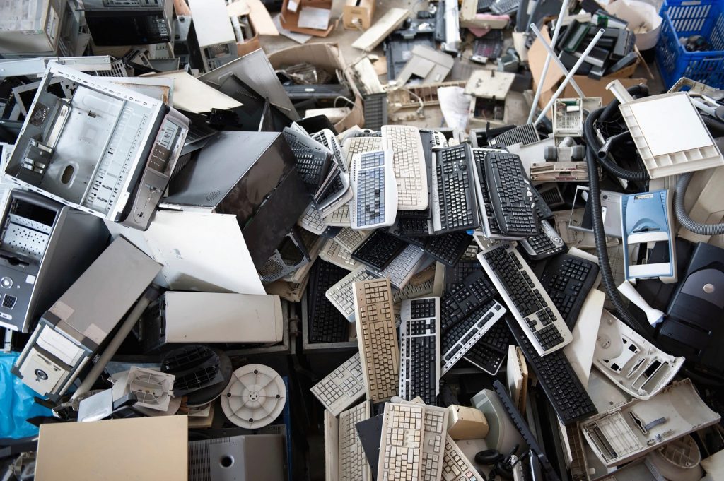 a pile of old computer hardware including pcs and keyboards